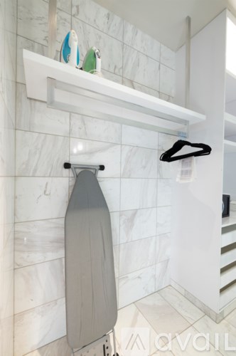 A white towel rack with a grey towel hanging on it.