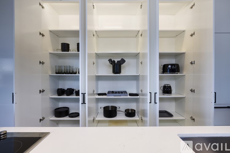 A kitchen with white cabinets and a stove top oven.