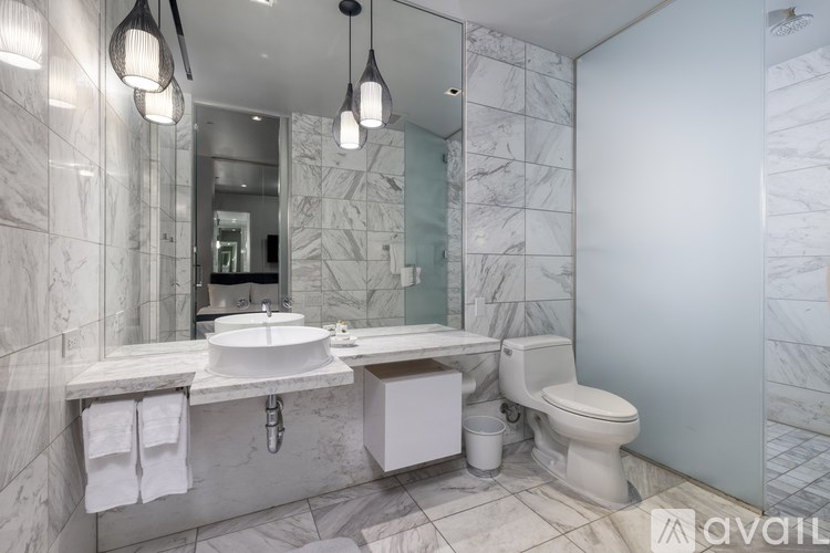 A bathroom with marble tiles and a white sink.