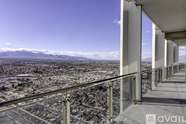 A balcony overlooks a cityscape with mountains in the distance.