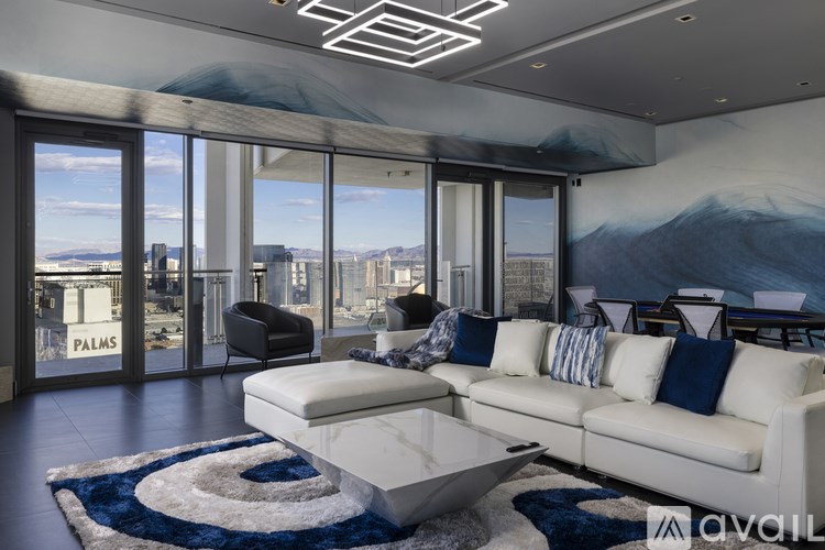 A living room with a white sofa and a large window overlooking a cityscape.