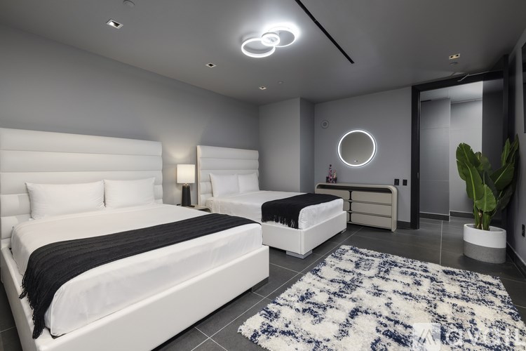 A modern bedroom with a large bed and a smaller bed in the corner.