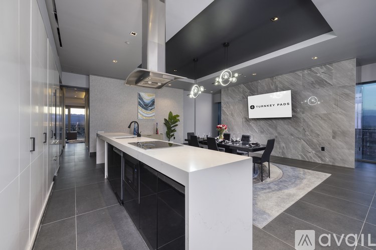 A modern kitchen with a large island and a dining table.