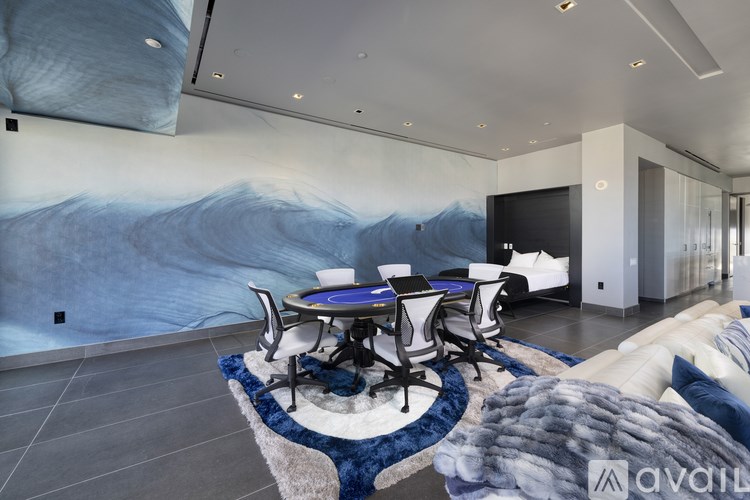 A modern dining room with a large blue wave mural on the wall.