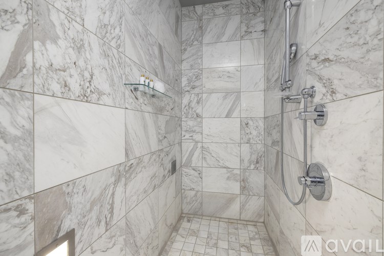A bathroom with marble tiles and a shower.