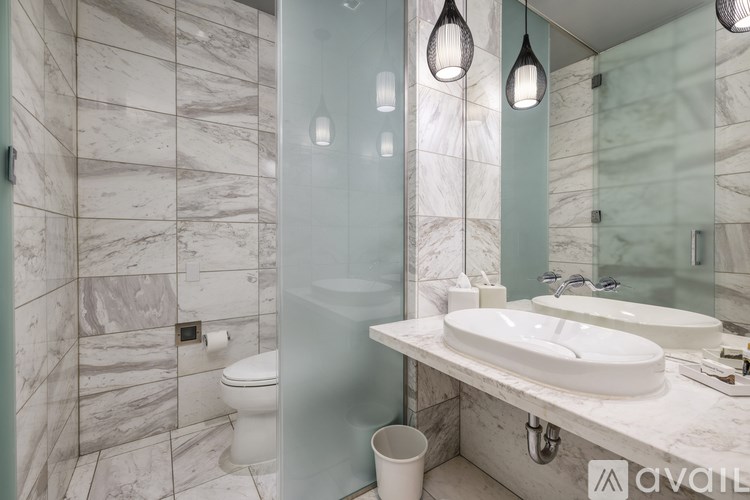 A bathroom with marble tiles and a white sink.
