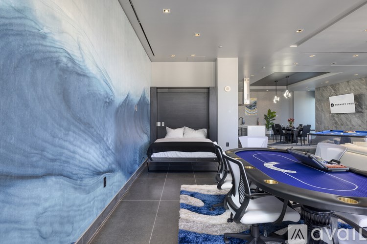 A room with a blue carpet and a bed with a white pillow.