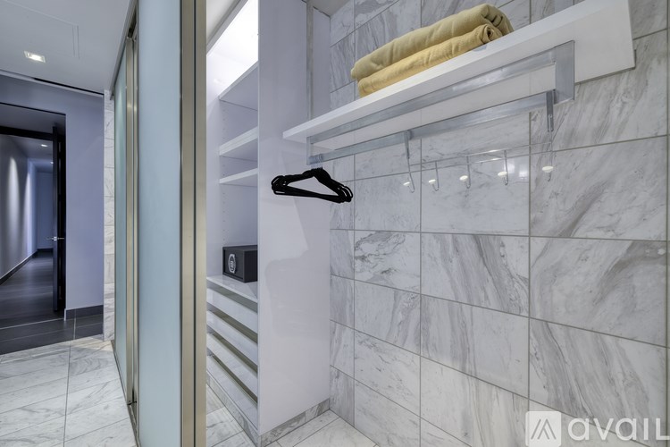A bathroom with a marble wall and a towel rack.