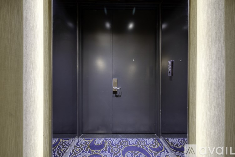 A black elevator with a metallic handle and buttons.