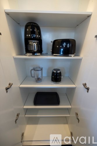 A kitchen cabinet with a coffee maker and toaster on the top shelf.