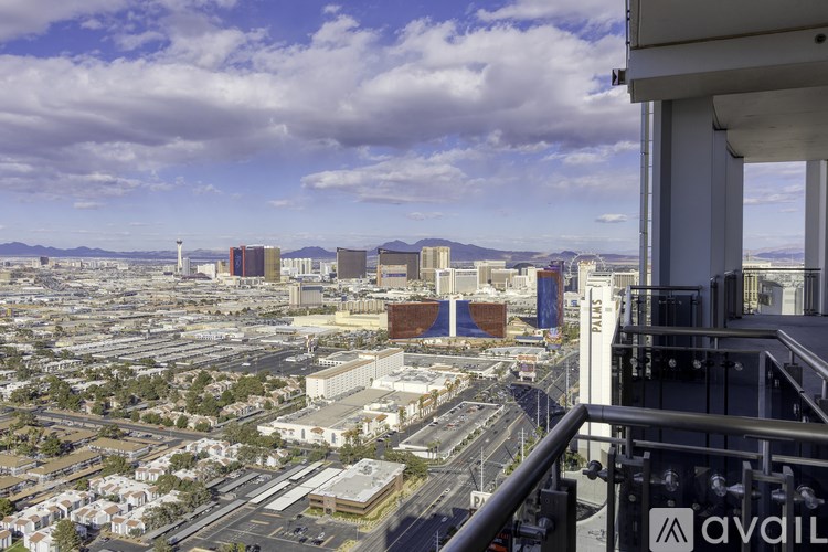 A cityscape with buildings and a cloudy sky.