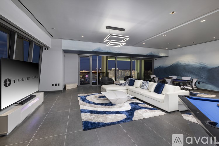 A modern living room with a pool table and a large painting on the wall.