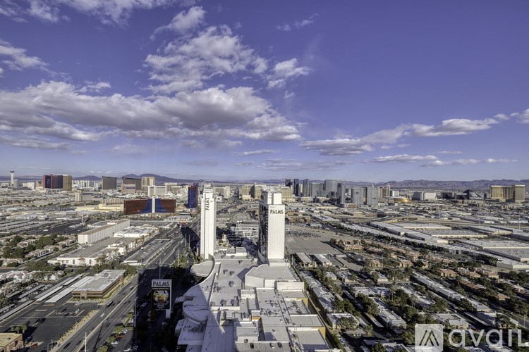 A cityscape with a clear blue sky and clouds.