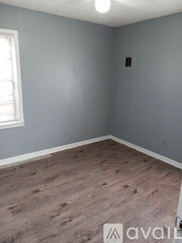 A room with wooden flooring and a window.