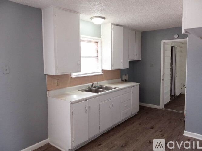 A kitchen with white cabinets and a sink.