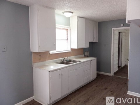 A kitchen with white cabinets and a sink.