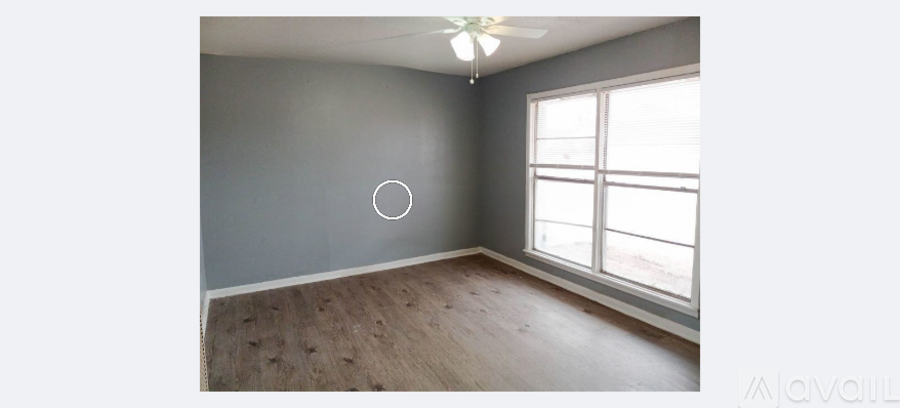 A room with a ceiling fan and a window with blinds.