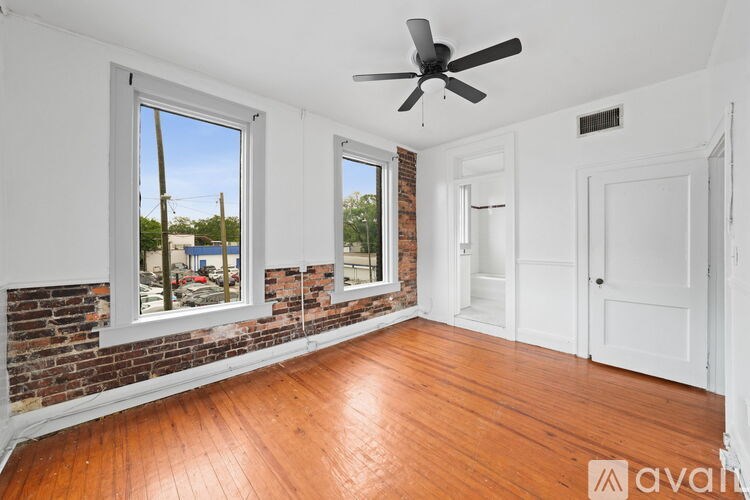 A room with wooden floors and a ceiling fan.