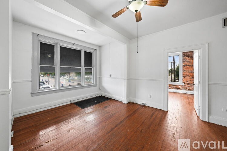 A room with a wooden floor and a ceiling fan.