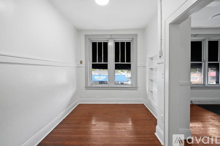 A room with a window and wooden flooring.