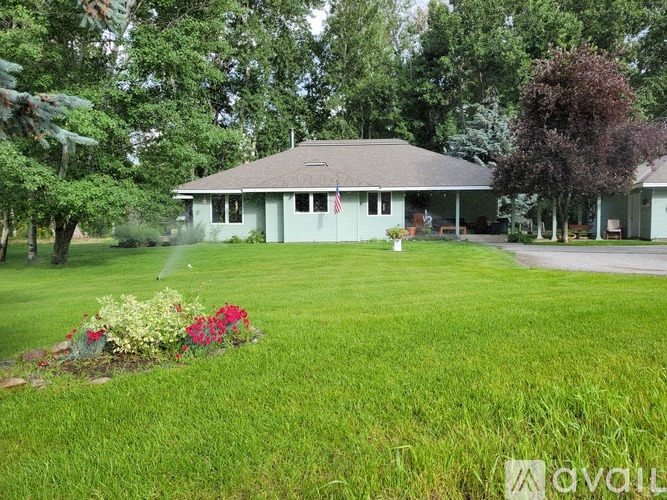 A house with a well-kept lawn and a garden in front.