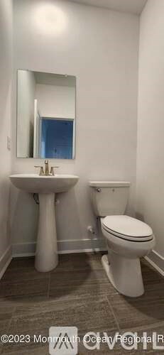 A bathroom with a sink, toilet, and mirror.