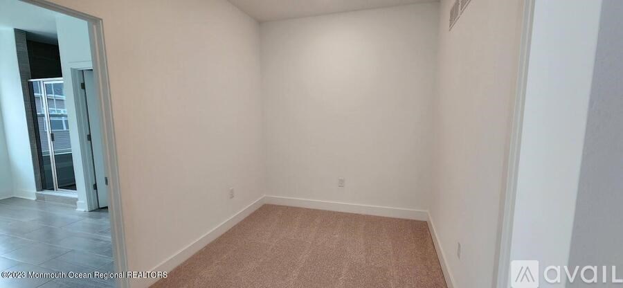 A room with a carpeted floor and white walls.