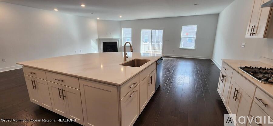 A kitchen with a large island and wooden floors.