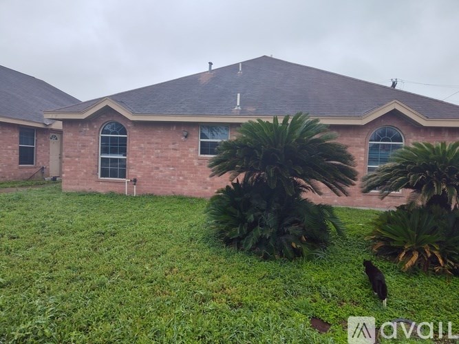 A house with a brown roof and a green lawn in front.