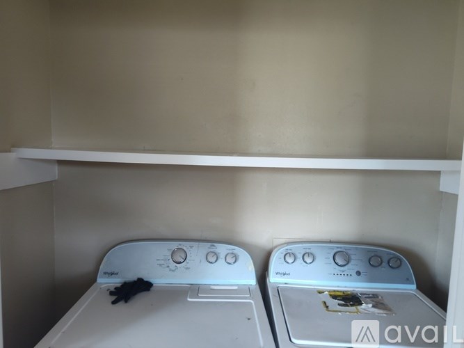 Two white washing machines are sitting next to each other.