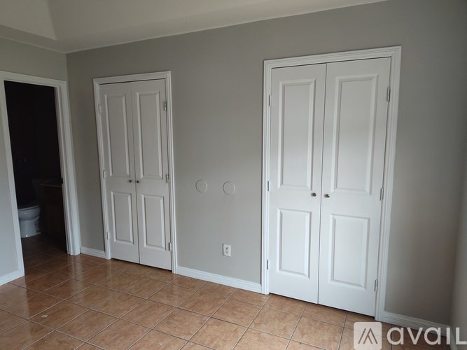 Three white doors in a room with tiled floors.