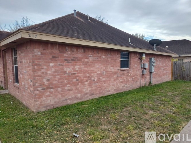 A red brick house with a satellite dish on the roof.