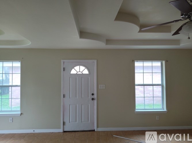 A room with a white door and two windows.