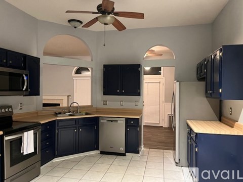 A kitchen with a fan and a stainless steel oven.