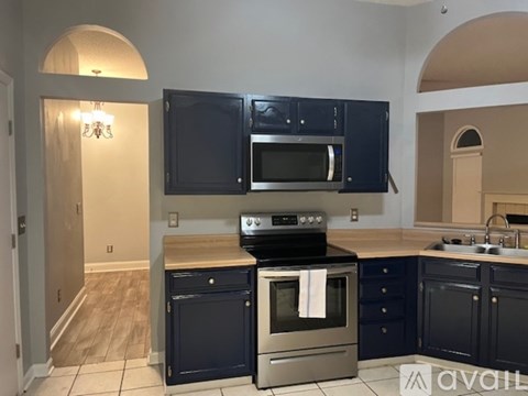 A kitchen with dark cabinets and stainless steel appliances.