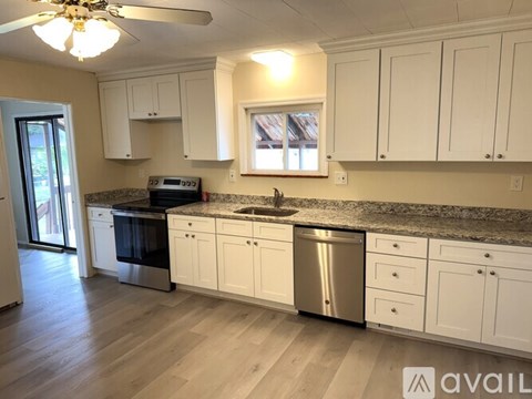 A kitchen with white cabinets and a granite countertop.