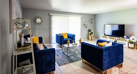 A living room with blue chairs and a television.