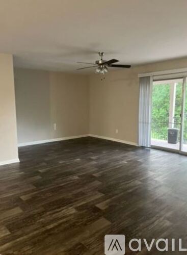 A room with wooden flooring and a ceiling fan.