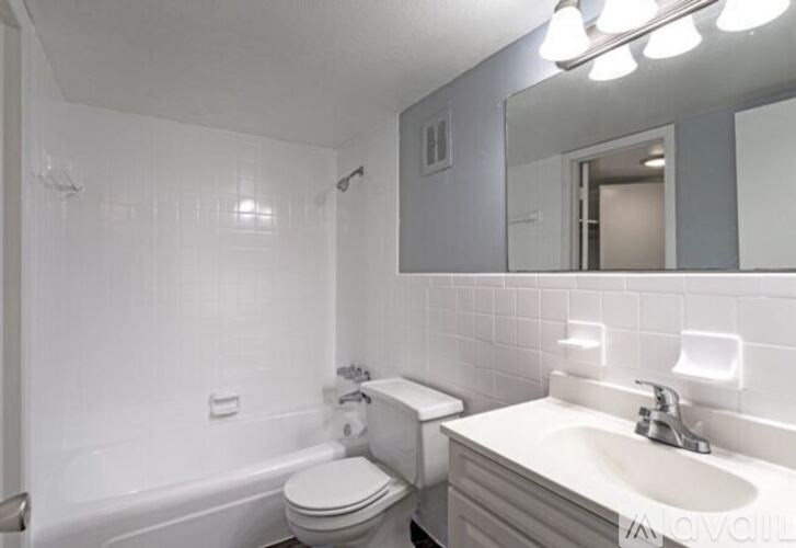 A white bathroom with a toilet, sink, and bathtub.