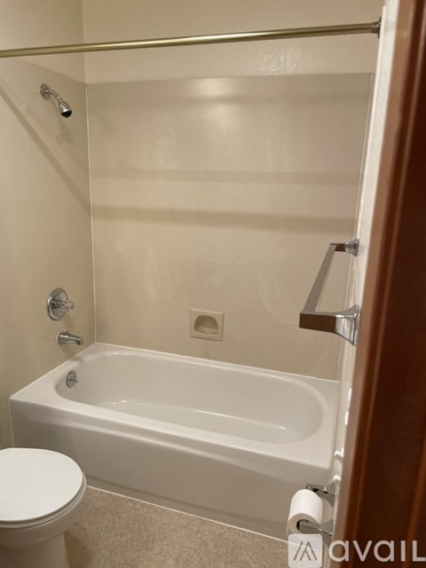 A white stove and refrigerator in a kitchen with wooden cabinets.