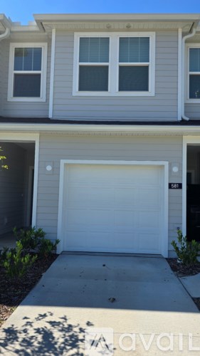 A house with a white garage door and a number 311 on it.