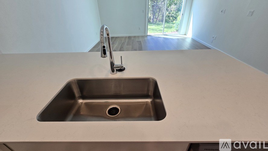 A modern kitchen sink with a chrome faucet.