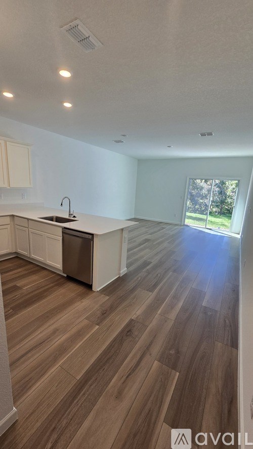 A kitchen with wooden floors and white walls.