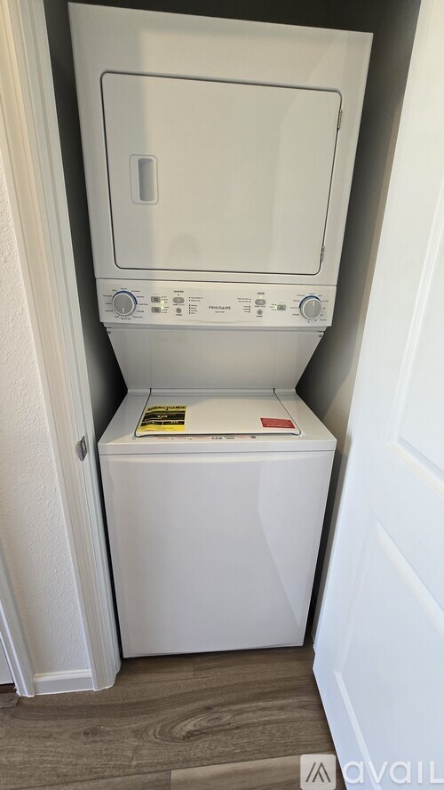 A white dryer is sitting in a small closet.