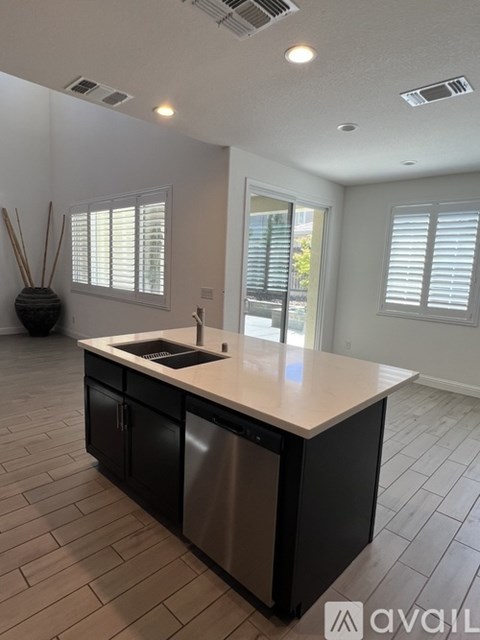 A kitchen with a black fridge and a white counter top.