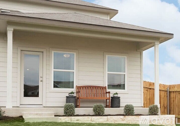 A small house with a wooden bench in front.