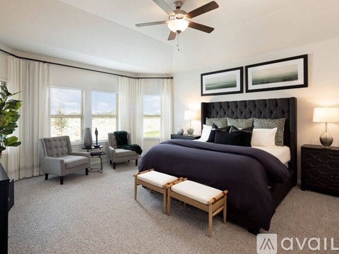 A bedroom with a large bed and a ceiling fan.