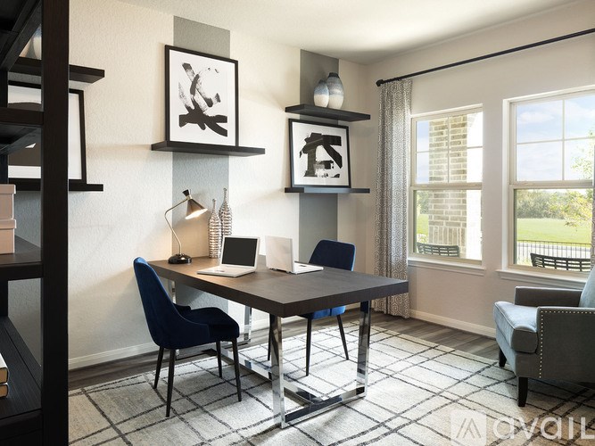A room with a desk, chairs, and pictures on the wall.