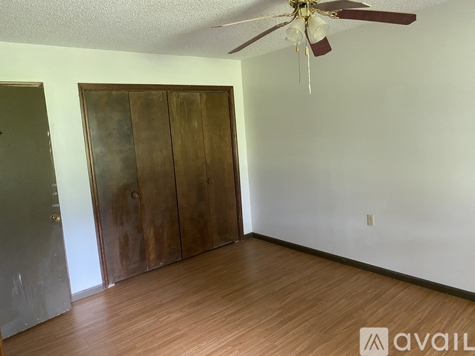 A room with a ceiling fan and a large wooden door.