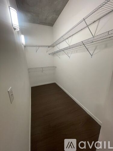 A long hallway with a rack on the wall and a light switch on the wall.
